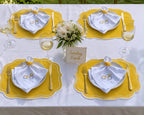 Luxury table setting for six featuring handmade yellow bicycle placemats and embroidered napkins.